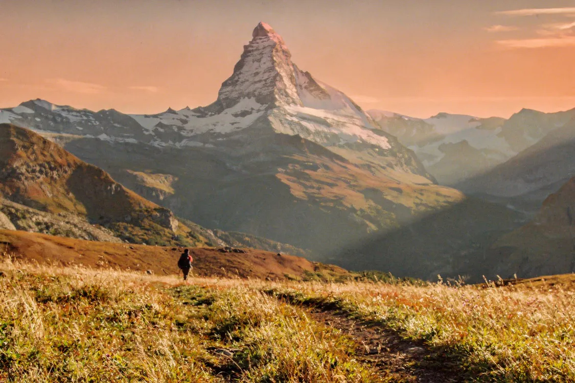 Creación de profundidad en fotografía básica usando un primer plano borroso para enmarcar el pico Matterhorn al amanecer.